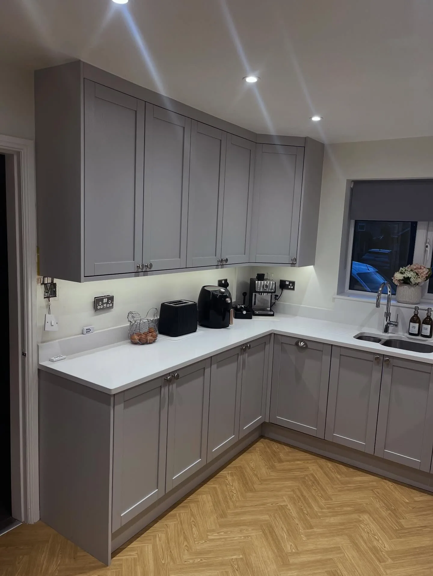 Grey shaker kitchen corner units with silver cup handles