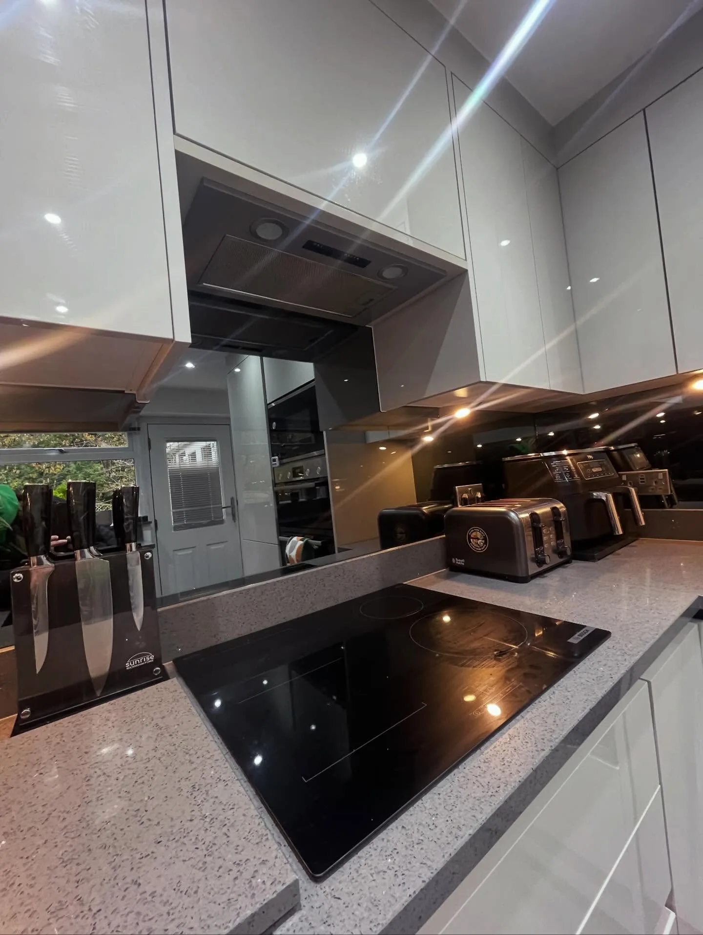 Grey shaker style kitchen with island hob and pendant lighting