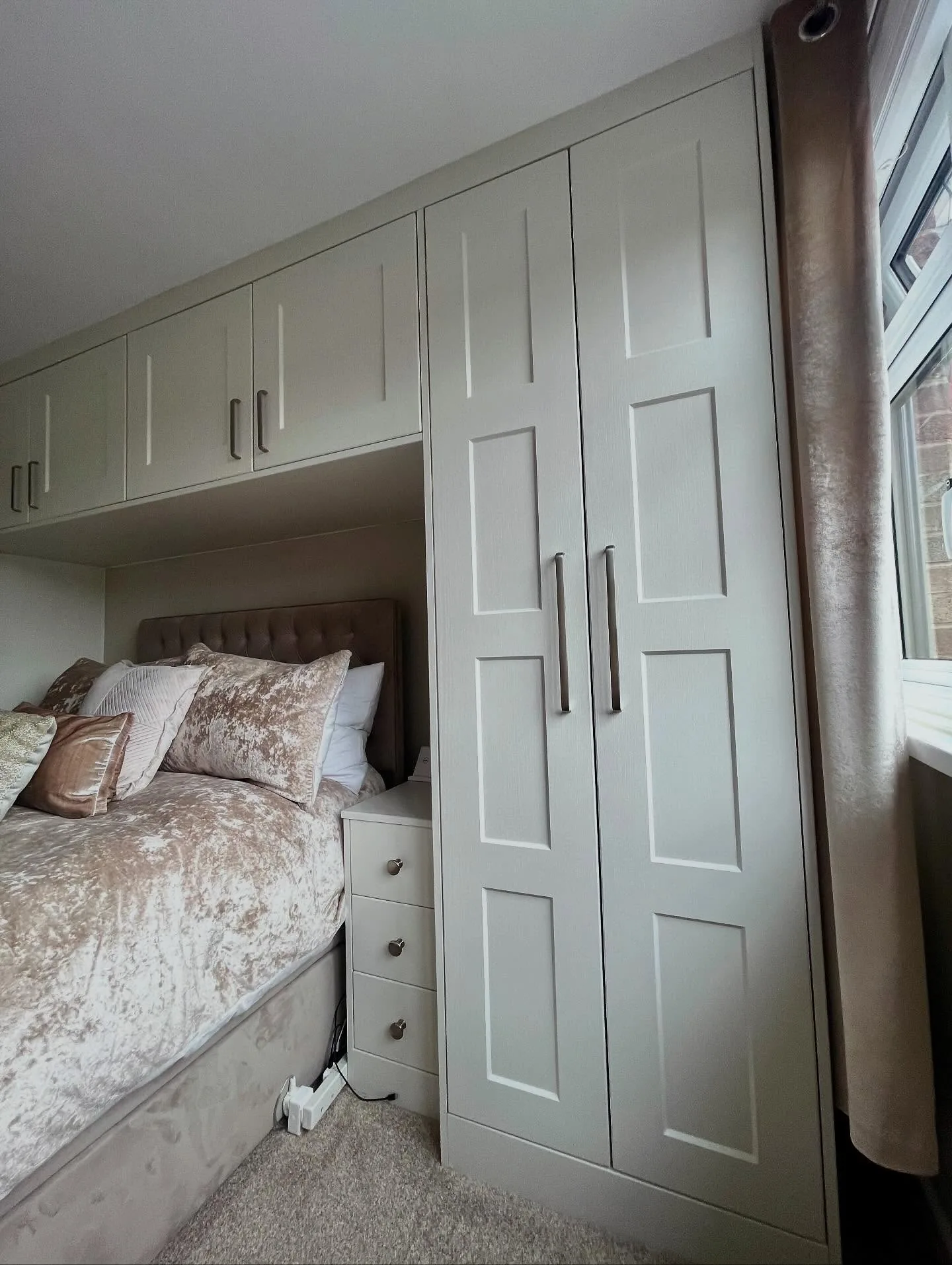 Fitted bedroom wardrobes with overbed storage in soft grey finish